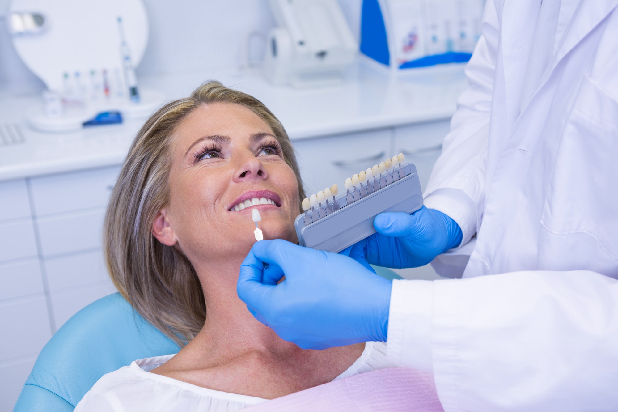 doctor-holding-tooth-whitening-equipment-by-patient.jpg